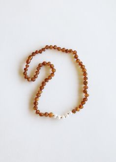 a beaded necklace with white beads on a white background