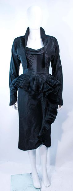 For Sale on 1stDibs - This Irene ensemble is composed of black silk. The strapless cocktail dress features a pleated bust with side draped, cascading ruffle, with interior boning. Elegant Taffeta Evening Dress With Ruffles, Fitted Silk Evening Dress With Folds, Fitted Ruffle Evening Dress For Dinner, Elegant Draped Evening Dress With Ruffles, Draped Ruffles Evening Dress, Draped Ruffle Evening Dress, Silk Evening Dress With Ruffles For Cocktail, Silk Ruffled Evening Dress For Cocktail, Fitted Evening Dress With Ruffled Skirt