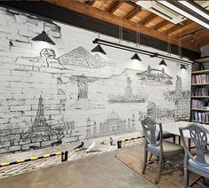 a room with some chairs and a table in front of a book shelf filled with books