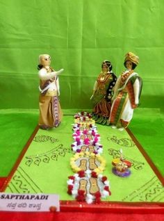 three figurines are sitting on a table with flowers in front of green backdrop