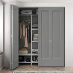 an open closet with clothes hanging on the doors