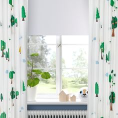 the window is decorated with green trees and blue trims, along with a white radiator