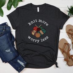 a t - shirt that says knit more worry less on it next to jeans and sandals