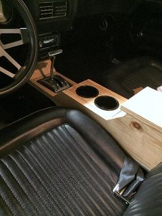 the interior of an old car with black leather seats and wood dash board on it