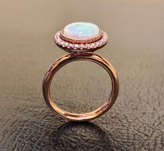 an opal and diamond ring on a table