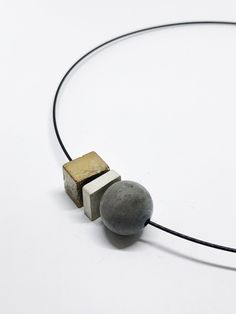 minimalist modern necklace in black stainless steel with 1 cube, 1 plate and 1 ball of concrete. The cube element was processed with gold paint. All pieces of jewelery are designed and cast in our studio in the south of Hesse. The extra fine concrete is especially suitable for exclusive pieces of jewelry. The concrete pieces are processed in their natural state (unpolished and polished). Each chain is thus individual and unmistakable. Handmade in the style of CA.ON.IS. BAGS Choker circumference 40cm Lock for turning design & made in germany Concrete Minimalist, Gold Concrete, Concrete Necklace, Choker Chain Necklace, Concrete Jewelry, Modern Necklace, Choker Chain, Modern Necklaces, Chain Choker Necklace