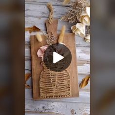 a wooden cutting board with some dried flowers on it and a video player in the background