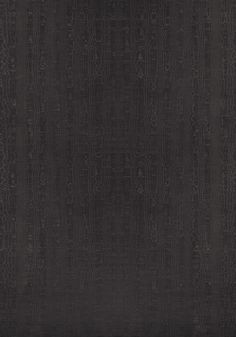 a black area rug with an intricate design on the front and back side, in dark colors