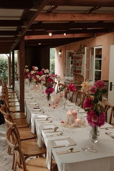 a long table is set up with flowers and place settings for dinner guests to enjoy