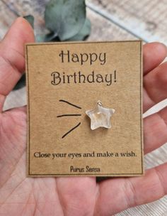 a person holding up a card with a star on it that says happy birthday close your eyes and make a wish