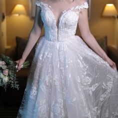 a woman in a white wedding dress holding a bouquet