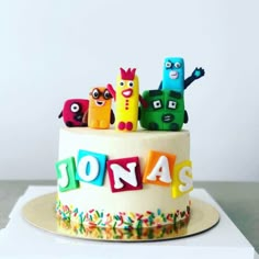 a birthday cake decorated with cartoon characters and the words jonas