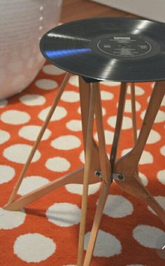 a record player table sitting on top of an orange and white rug