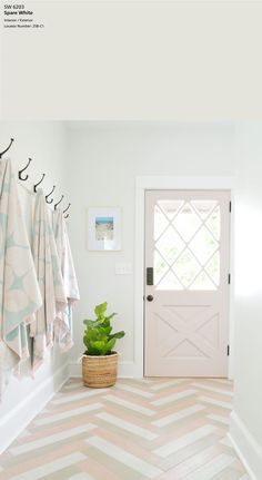 a bathroom with towels hanging on the wall and a potted plant next to it