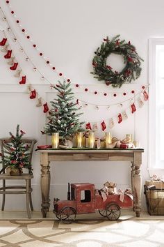 a christmas tree and decorations in a living room with an old toy truck on the floor