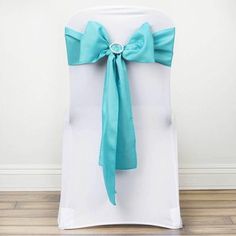 the back of a white chair with a turquoise bow on it's sashring