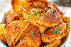 a white bowl filled with fried potatoes covered in parmesan cheese and parsley