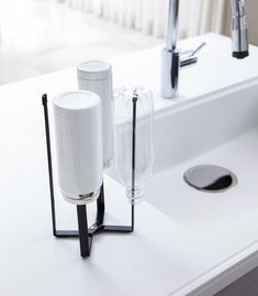 a white sink sitting next to a faucet on top of a counter