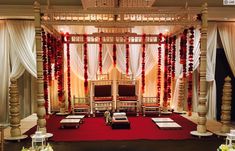 a decorated stage with white drapes and red carpet