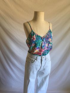 vintage 1980s camisole Inner Most synthetic satin jacquard floral print multi-colored w/green being most prominant painterly floral pattern spaghetti straps bow chest detail v-front straight back good vintage condition, light wear no size tag-see below measures, lying flat, chest-19" length-21" Fitted Multicolor Floral Print Tank Top, Fitted Printed Summer Camisole, Green Floral Print Tank Top, Spring Floral Print Cami Tank Top, Floral Print Cami Tank Top For Spring, Spring Printed Tank Camisole, Multicolor Tank Camisole For Spring, Summer Printed Tank Camisole, Green Floral Print Tank Top For Spring