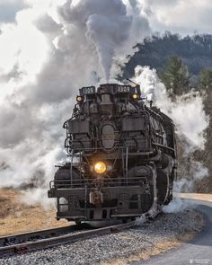 an old fashioned steam engine traveling down the tracks