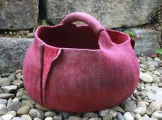 a red bag sitting on top of a pile of rocks