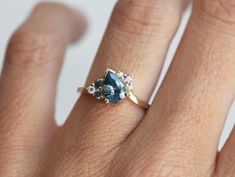 a woman's hand with a blue and white diamond ring