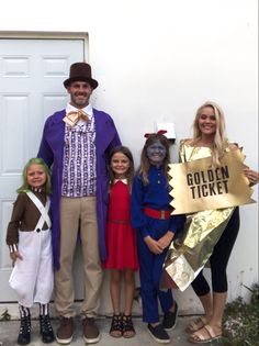 some people are dressed up and posing for a photo with two children in costumes, one is holding a sign that says golden ticket