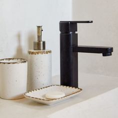 a bathroom sink with soap dispenser, soap dish and toothbrush holder