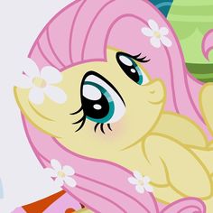 a pink pony with blue eyes and flowers in her hair is looking at the camera