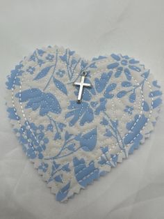 a blue and white heart with a cross on it