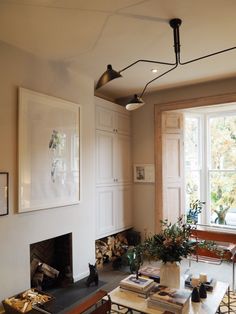 a living room filled with furniture and a fire place in front of a large window