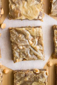 several pieces of food sitting on top of a piece of wax paper next to nuts