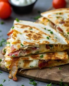 three quesadillas stacked on top of each other with tomatoes in the background