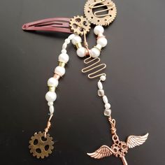 a close up of a hair comb with beads and charms on it's side