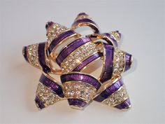 Stunning sparking Napier purple bow encrusted with Aurora Borealis glistening rhinestones. This gem would make a perfect Birthday gift to be enjoyed year round, as well as a conversation starter. Measures 1 3/4" X 2". pristine condition, signed Napier. Ready to be enjoyed by you, or given as a gift. This color brooch is extremely hard to find. Purple Rhinestones Brooch As A Gift, Purple Rhinestone Brooches As A Gift, Purple Rhinestone Brooches For Gifts, Purple Rhinestone Brooches As Gifts, Elegant Purple Rhinestone Brooches, Purple Rhinestone Party Brooches, Glamorous Bling Brooches As A Gift, Glamorous Bling Brooches As Gift, Purple Bow