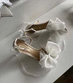 a pair of white shoes with bows on them