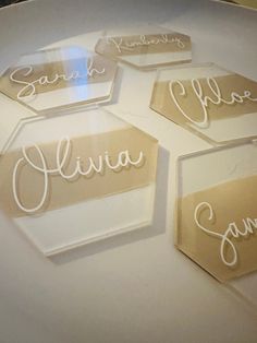 four glass name tags sitting on top of a white plate