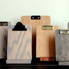 several wooden clipboards lined up on a shelf