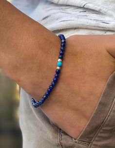 "Natural blue lapis lazuli stretch bracelet accented with bright sky blue turquoise howlite and Karen Hill Tribe .999 fine silver. Colorful skinny stacking bracelet is latest trend around Europe for both men and women! Bracelet is made of natural blue Lapis Lazuli in 4-5mm smooth rounds. Sky blue turquoise howlite gemstone round is perfect accent. On either side are Thai fine silver faceted cube beads. These are made of almost pure .997 to .999 silver by the Karen Hill tribes of northern Thailan Manly Beaded Bracelets, Paris Charm Bracelet, Blue Beaded Bracelets, Surfer Necklace, Cube Beads, Turquoise Bead Bracelet, Beaded Necklace Diy, Diy Bracelets Patterns, Wood Bead Necklace