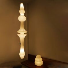 three white lamps hanging from the ceiling in a room with beige walls and flooring