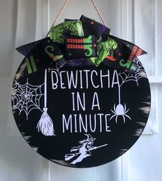 a sign that says, bewitcha in a minute hanging from a door