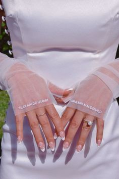 a woman with her hands in the shape of two fingers, wearing wedding gloves that say i do not know what they are