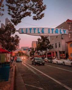 cars are driving down the street under a sign that reads, little italy san diego