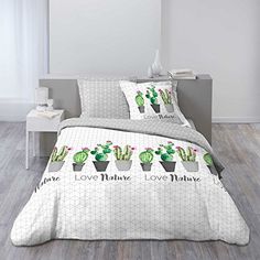 a bed with two pillows that have cactus in them and the words love nature on it