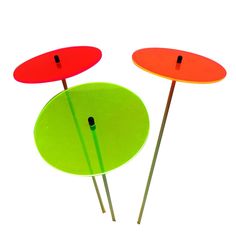 three red and green discs on top of each other with black pins sticking out of them