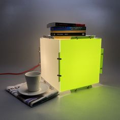 a stack of books sitting on top of a table next to a cup and saucer