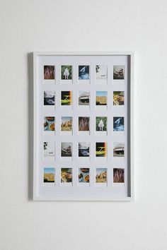 a white frame with multiple pictures hanging on the wall