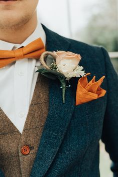 a man wearing an orange bow tie and a boutonniere on his lapel