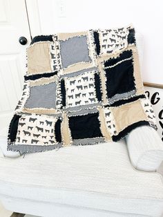 a couch with a black and white dog quilt on it's back, sitting in front of a door